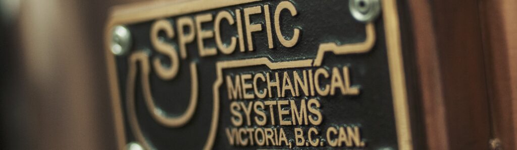 A metal plate engraved with Specific Mechanical Systems logo.