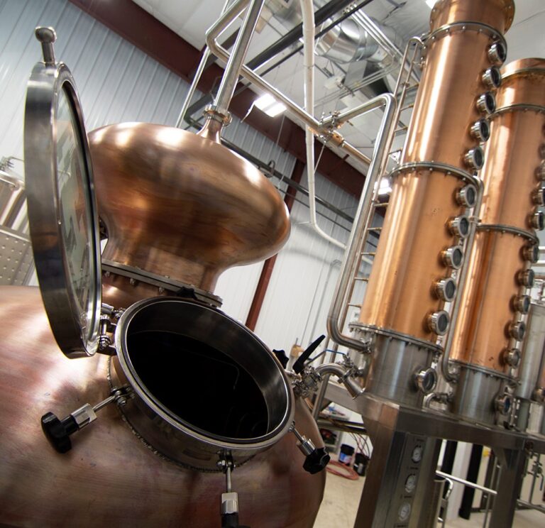 Copper distilling tank with two copper columns beside.