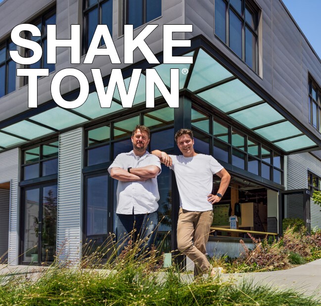 Shake Town Brewery logo and building with two men standing in front smiling.