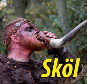 A man drinks from a horn wrapped in leather and the word "Skol" in yellow letters in the bottom right.